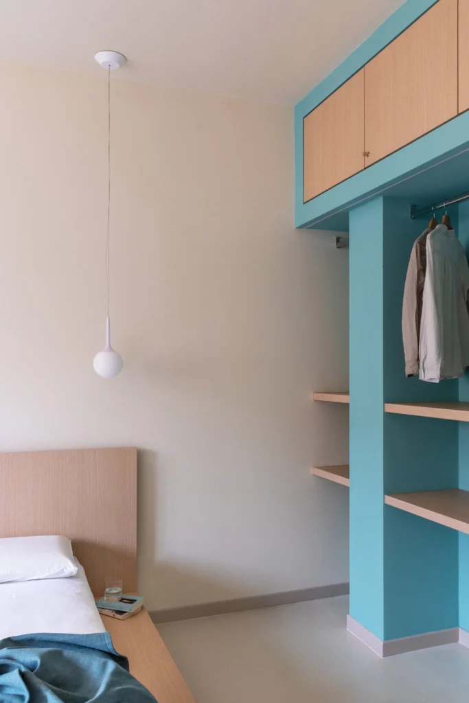 Camera da letto con mobili su misura e armadio integrato color verde, progetto di interior design per casa vacanze a Roma